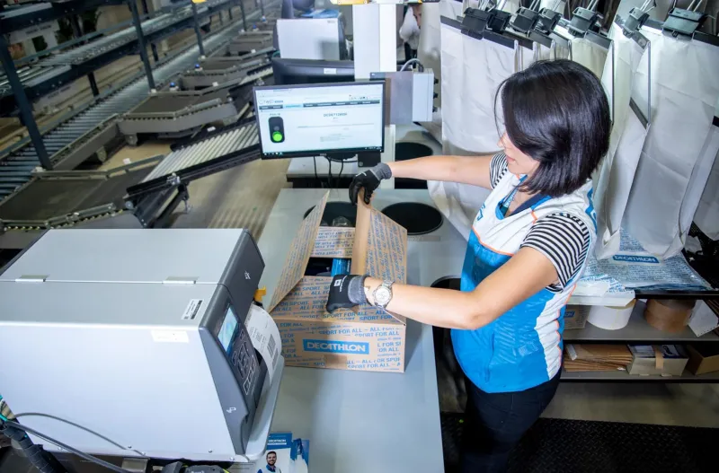 Frau scannt an Ausgabestation vom Ecopocket Sorter