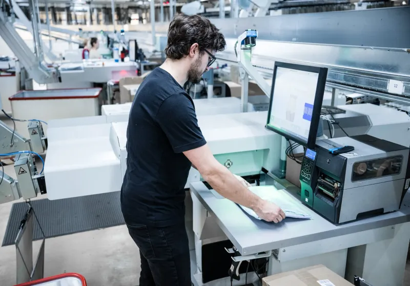 Mann scannt Ware an Ausgabestation von Ecopocket von DFT